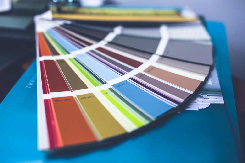 A collection of colorful paint swatches spread out showcasing a variety of hues.